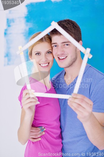 Image of happy couple paint wall at new home