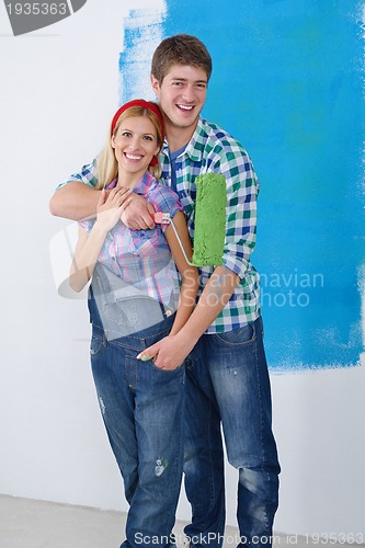 Image of happy couple paint wall at new home