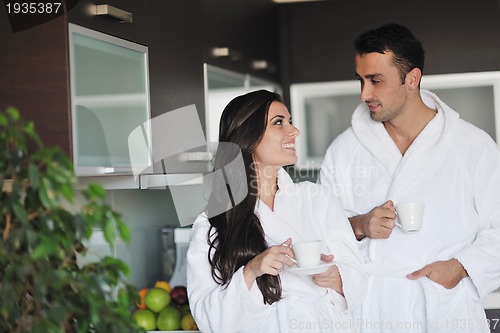 Image of Young love couple taking fresh morning cup of coffee