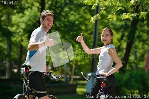 Image of Happy couple ridine bicycle outdoors