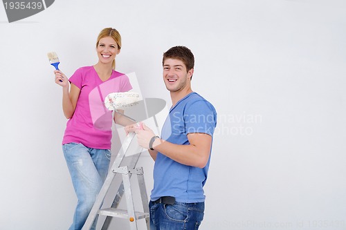 Image of happy couple paint wall at new home