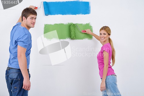 Image of happy couple paint wall at new home