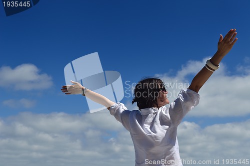 Image of happy young woman with spreading arms to sky