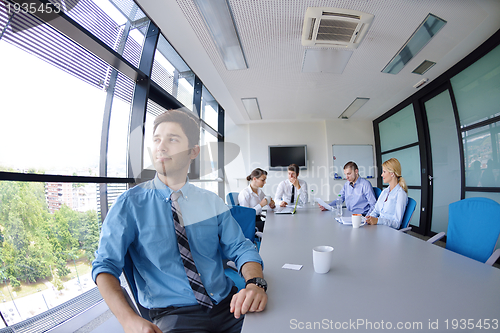 Image of business man  on a meeting in offce with colleagues in backgroun