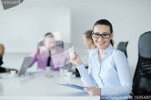 Image of business woman standing with her staff in background