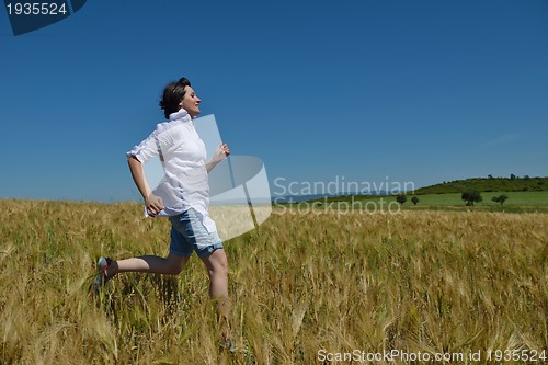 Image of young woman in wheat field at summer
