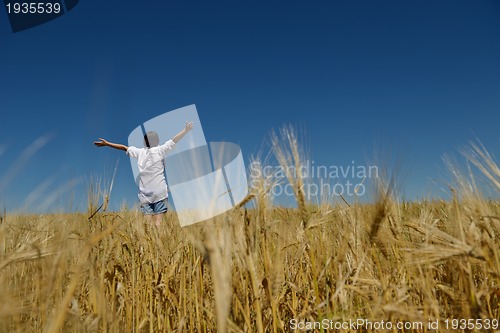 Image of young woman in wheat field at summer