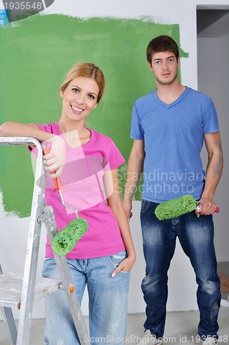 Image of happy couple paint wall at new home