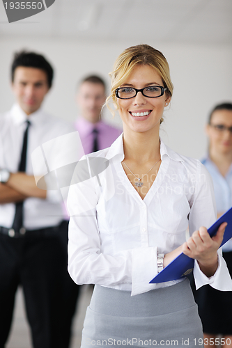 Image of business woman standing with her staff in background