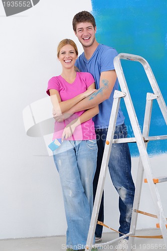 Image of happy couple paint wall at new home