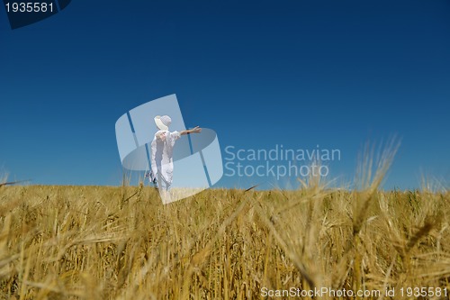 Image of young woman in wheat field at summer