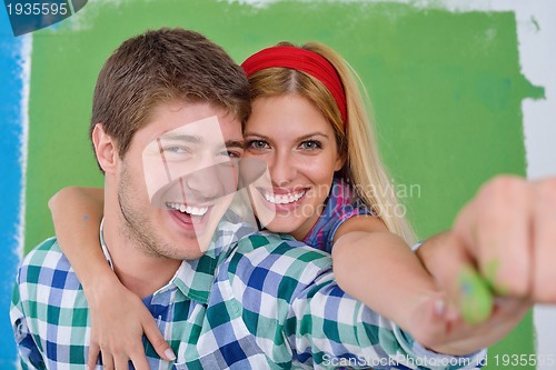 Image of happy couple paint wall at new home