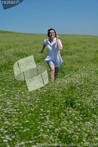 Image of Young happy woman in green field
