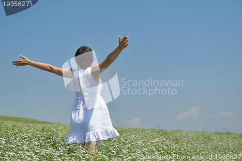 Image of Young happy woman in green field