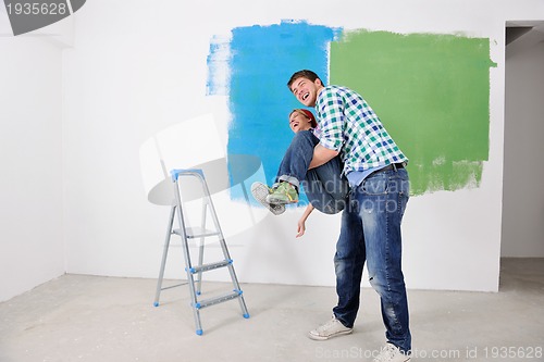 Image of happy couple paint wall at new home