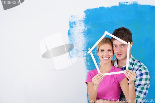 Image of happy couple paint wall at new home