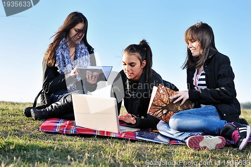 Image of group of teens working on laptop outdoor