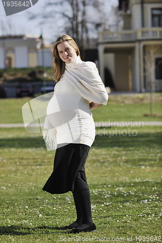 Image of happy young pregnant woman outdoor