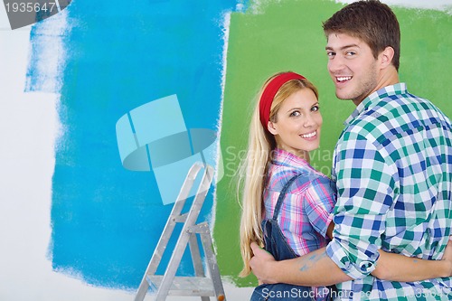 Image of happy couple paint wall at new home
