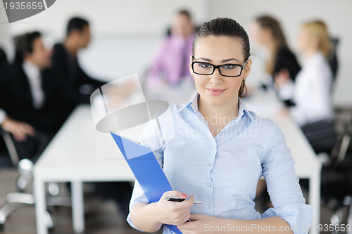 Image of business woman standing with her staff in background