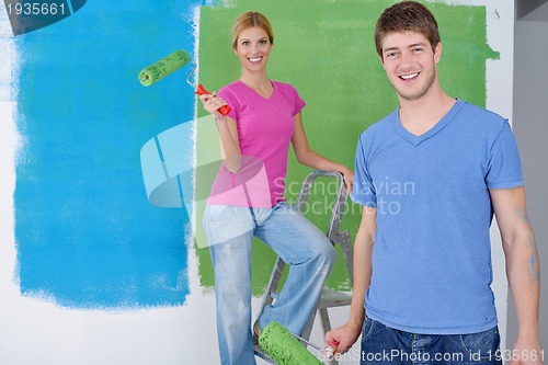 Image of happy couple paint wall at new home