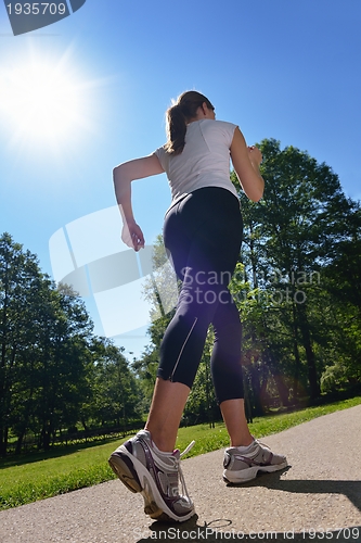 Image of Young beautiful  woman jogging at morning in park