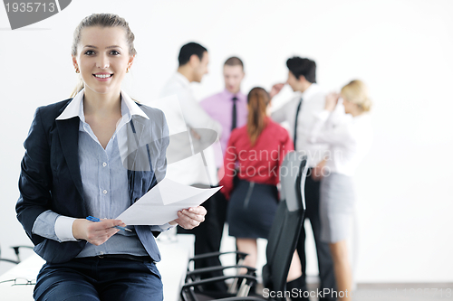 Image of business woman standing with her staff in background