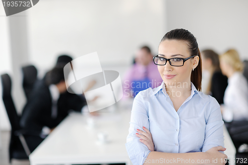 Image of business woman standing with her staff in background