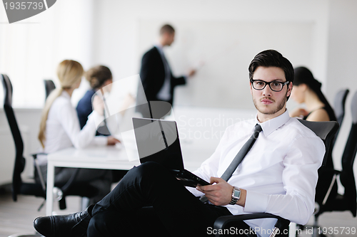Image of Portrait of a handsome young business man with colleagues in bac