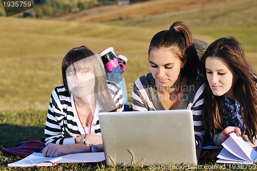 Image of group of teens working on laptop outdoor