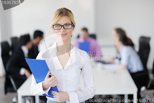 Image of business woman standing with her staff in background