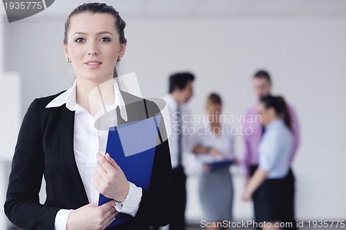 Image of business woman standing with her staff in background