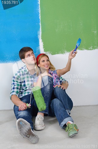 Image of happy couple paint wall at new home
