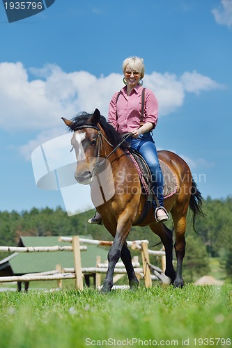 Image of happy woman  on  horse