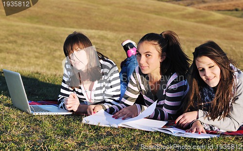 Image of group of teens working on laptop outdoor