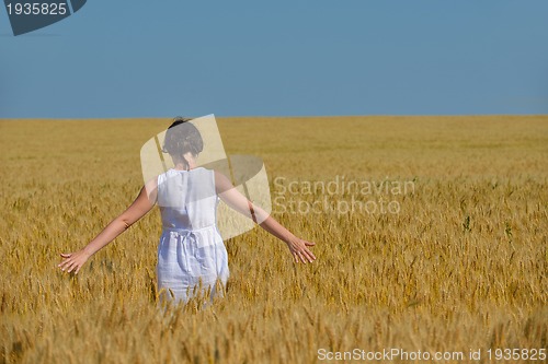 Image of young woman in wheat field at summer