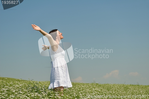 Image of Young happy woman in green field