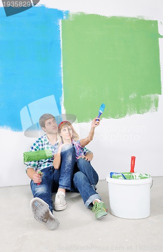 Image of happy couple paint wall at new home