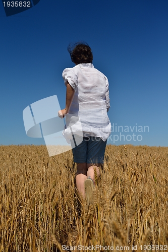 Image of young woman in wheat field at summer