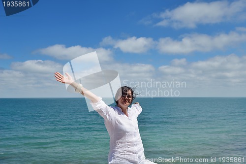 Image of happy young woman with spreading arms to sky