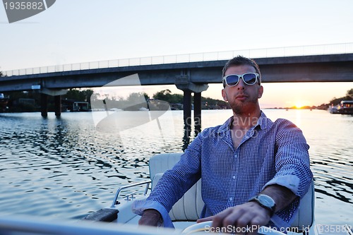 Image of portrait of happy young man on boat