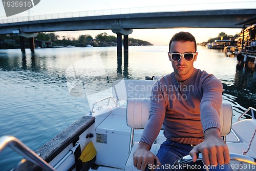 Image of portrait of happy young man on boat