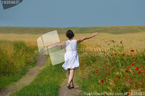 Image of young woman in wheat field at summer