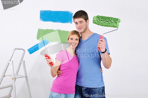 Image of happy couple paint wall at new home