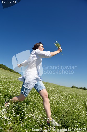 Image of Young happy woman in green field
