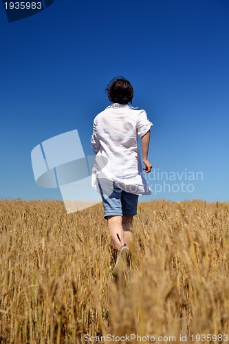 Image of young woman in wheat field at summer