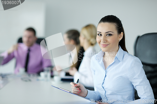 Image of business woman standing with her staff in background