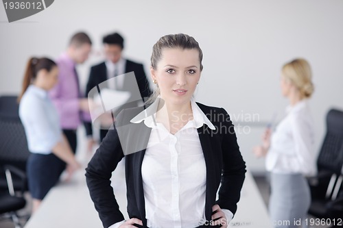 Image of business woman standing with her staff in background
