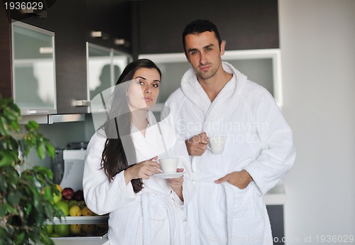 Image of Young love couple taking fresh morning cup of coffee