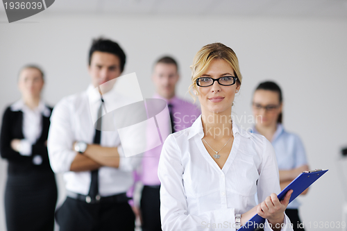 Image of business woman standing with her staff in background